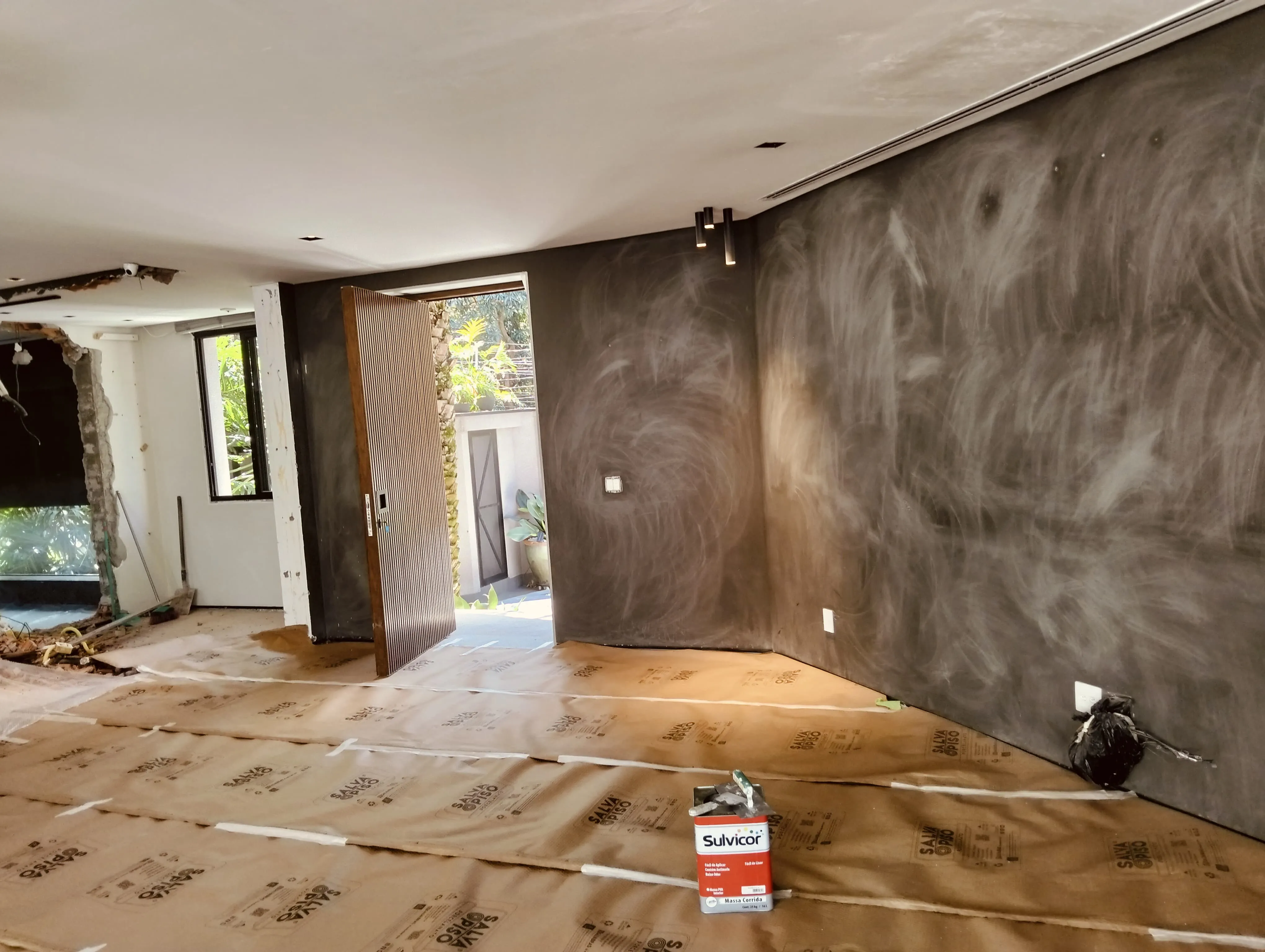 Pintor profissional aplicando acabamento fino e cimento queimado em parede